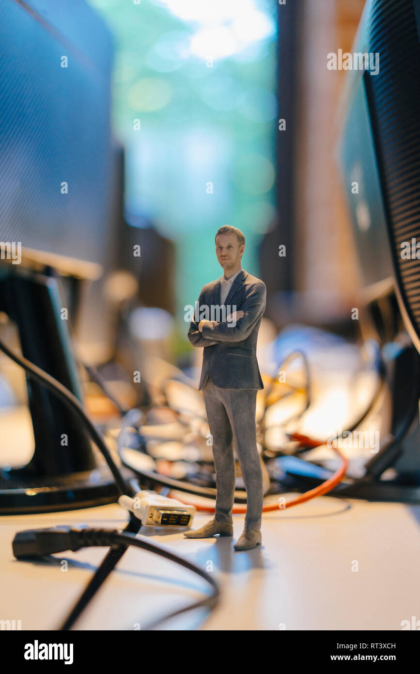 Businessman figurine standing amidst computer cables Stock Photo