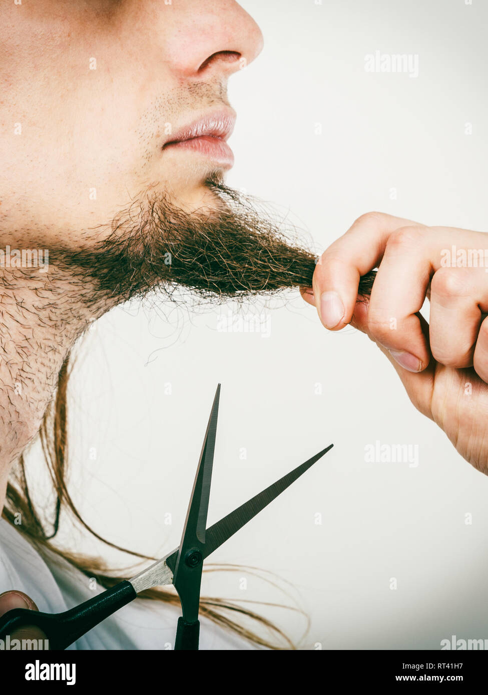 Cut and shave concept. Young man with long beard holding scissors. Part