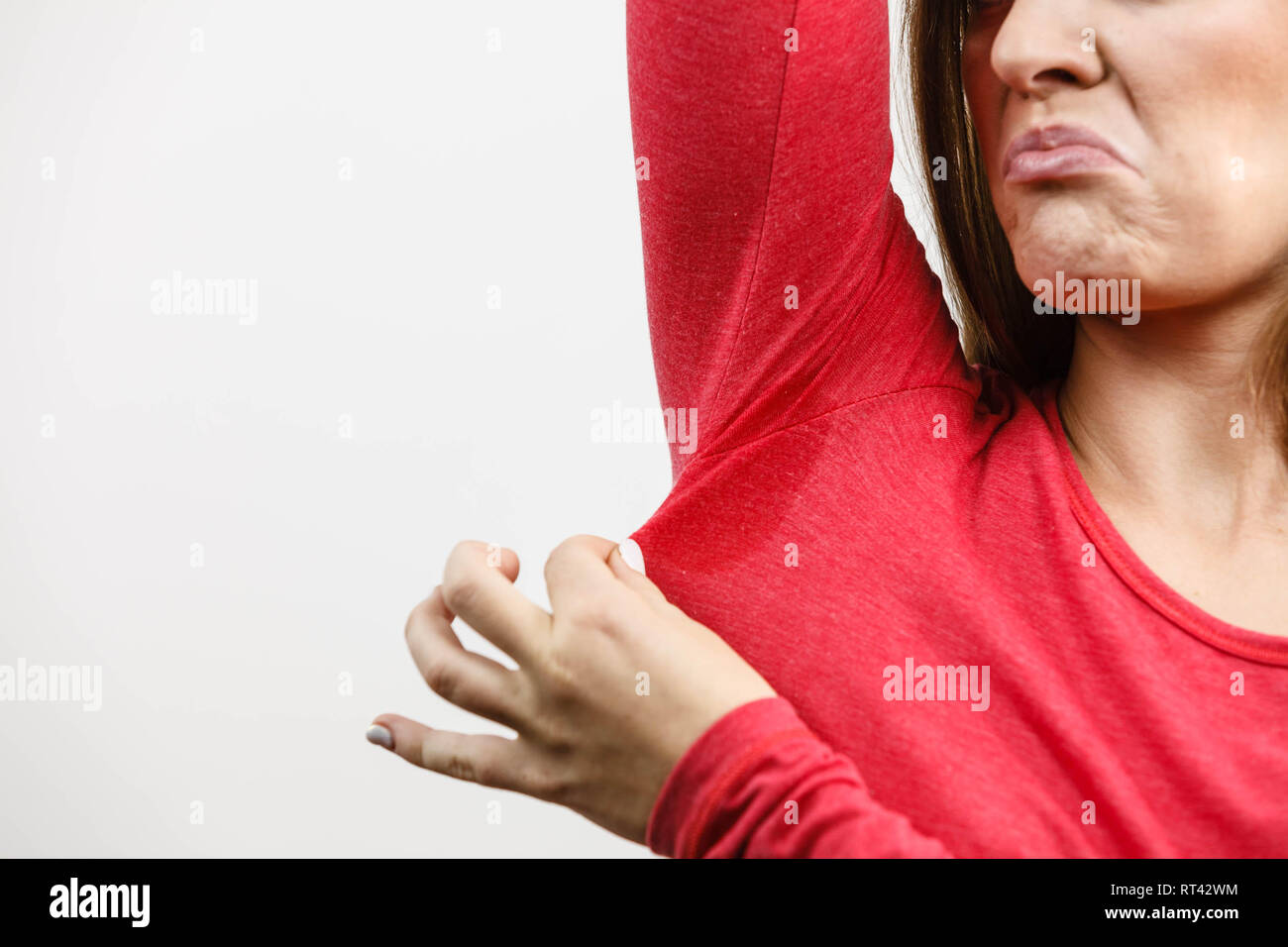 Sweaty girl pointing at wet stain under arm. Bad sweating problem Stock