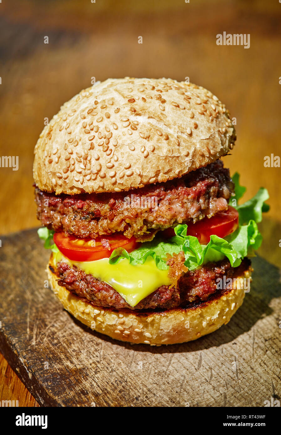 Hamburger with beef, cheese and vegetables on rustic wood background Stock Photo