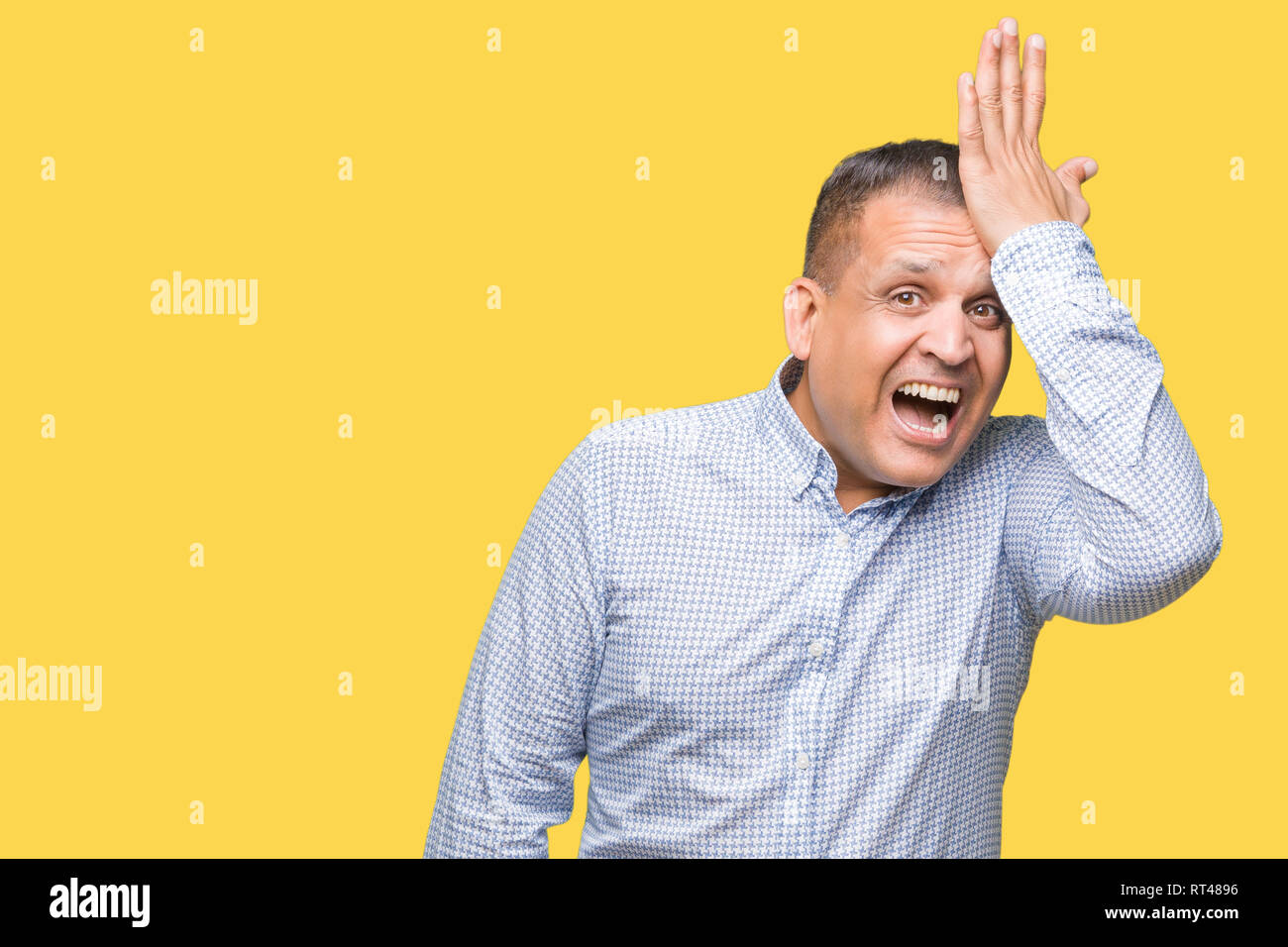 Middle age arab business man over isolated background surprised with hand on head for mistake, remember error. Forgot, bad memory concept. Stock Photo