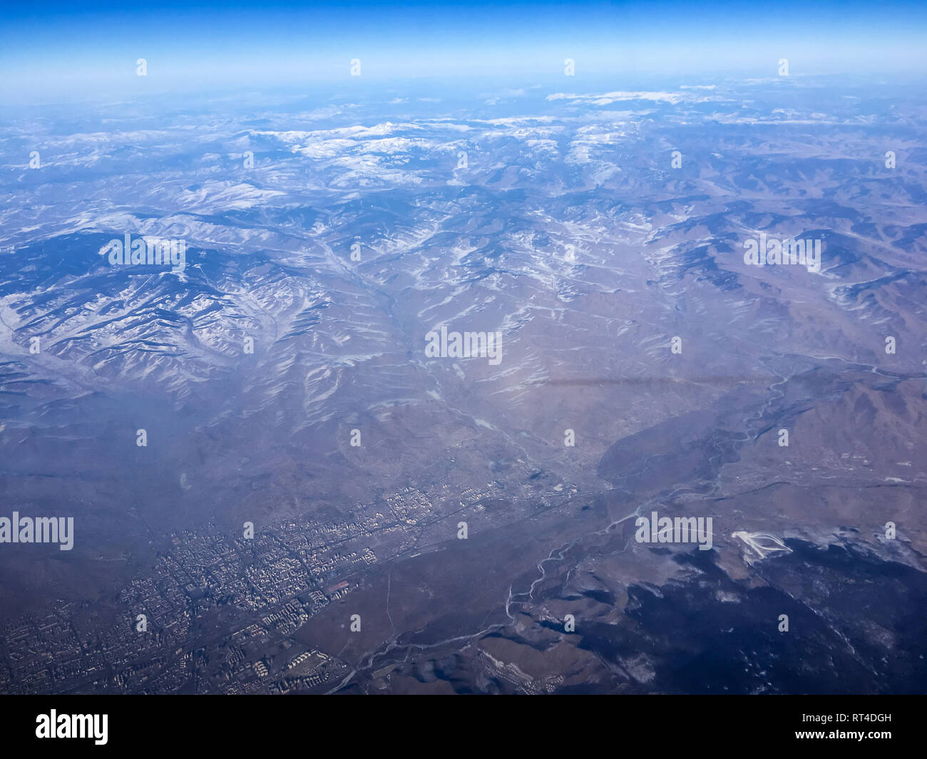 An aerial view of a part of Mongolia from the airplane flying high above the ground. A look from the plane´s window. A part of Oulanbatar can be seen. Stock Photo