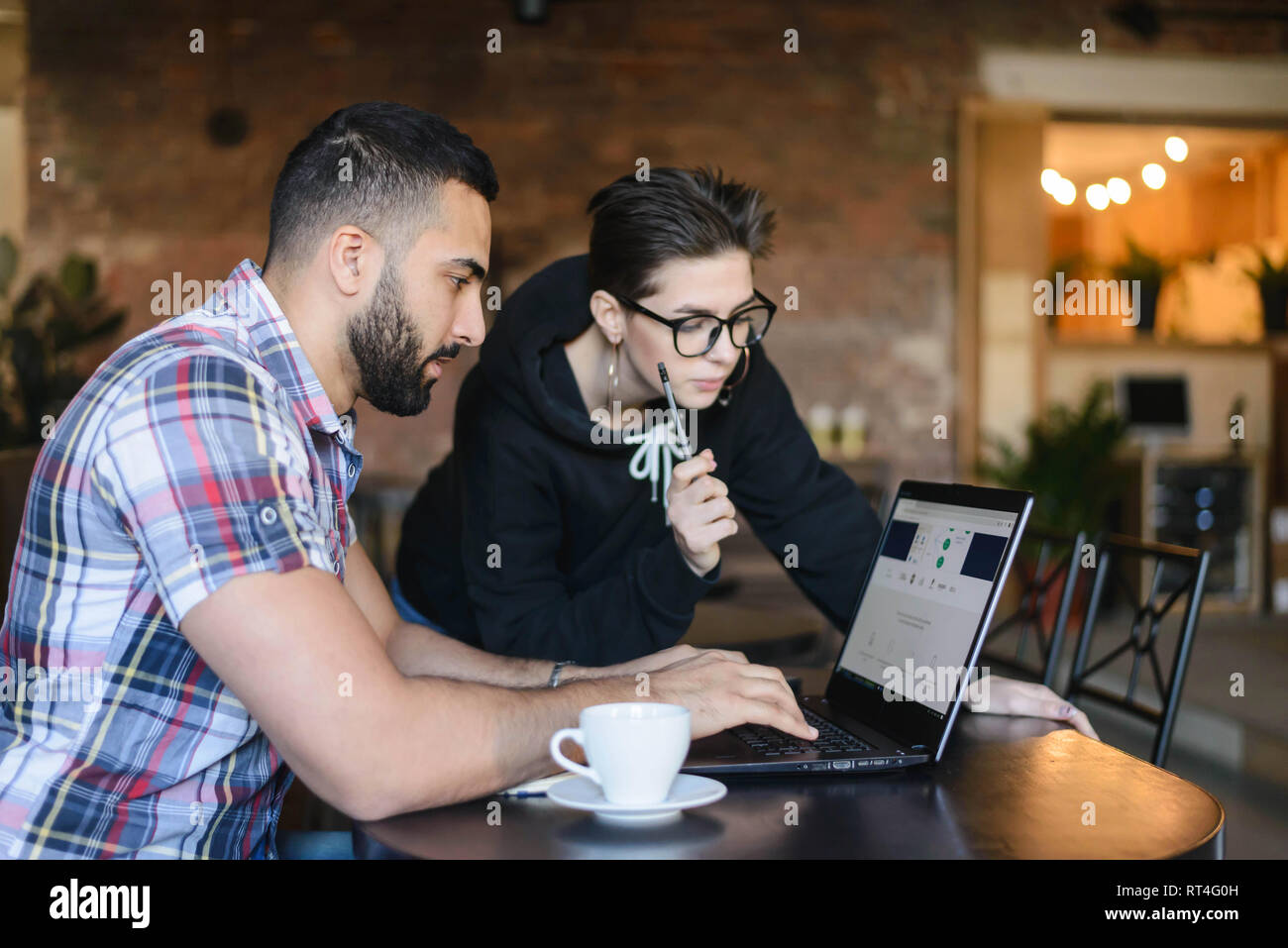 Two clever students having discussion about studying while sitting at the cafe Stock Photo