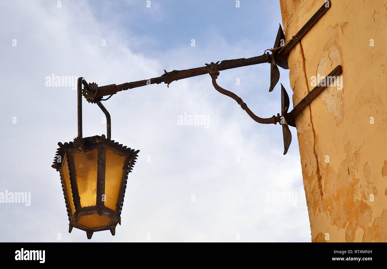 Old, antic, medieval and historic lantern hanging on a sand stone wall in Mdina, Malta. Stock Photo