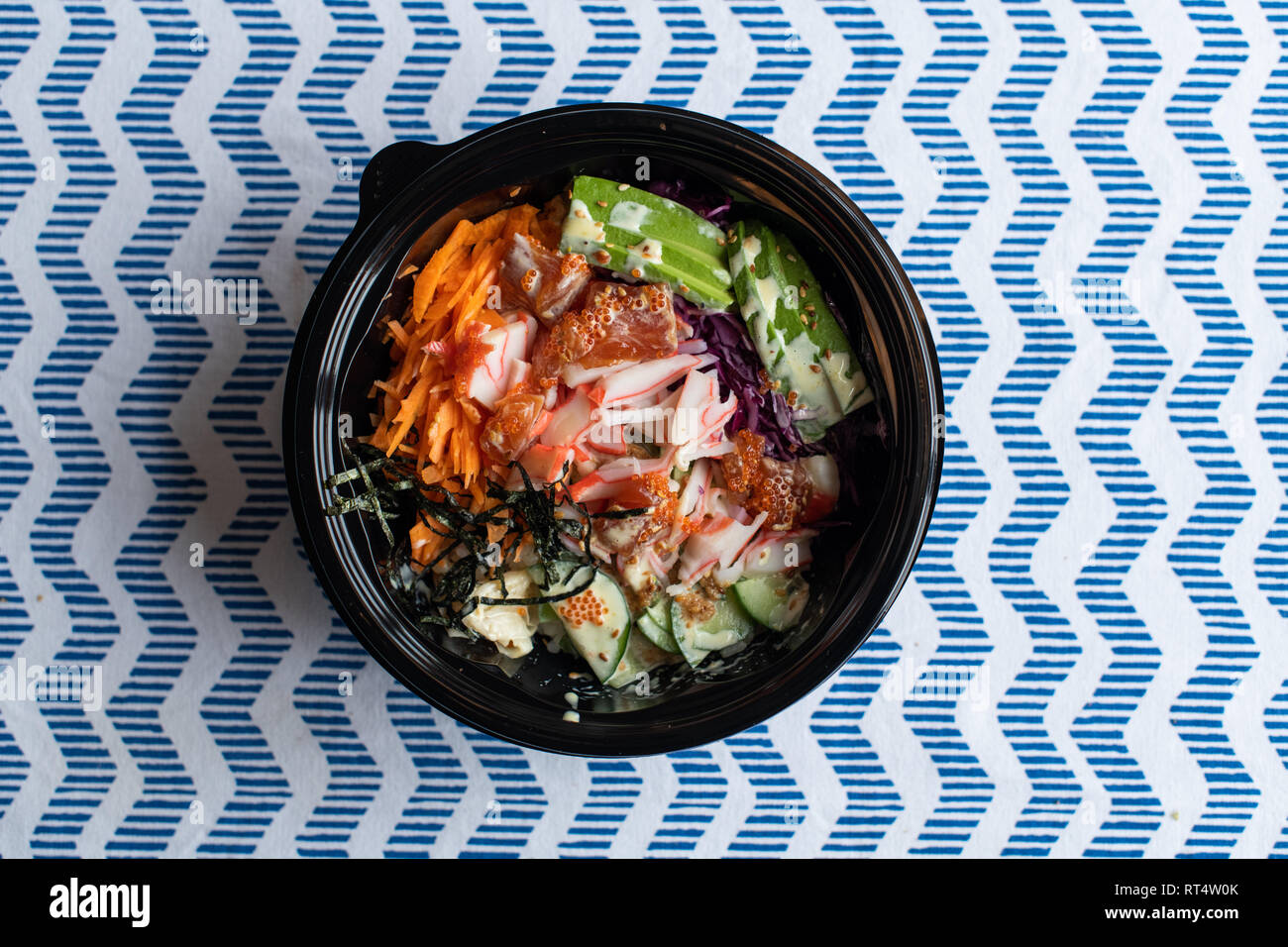 hawaii poke bowl with salmon, rice, surimi, avocado, tobiko, carrot and