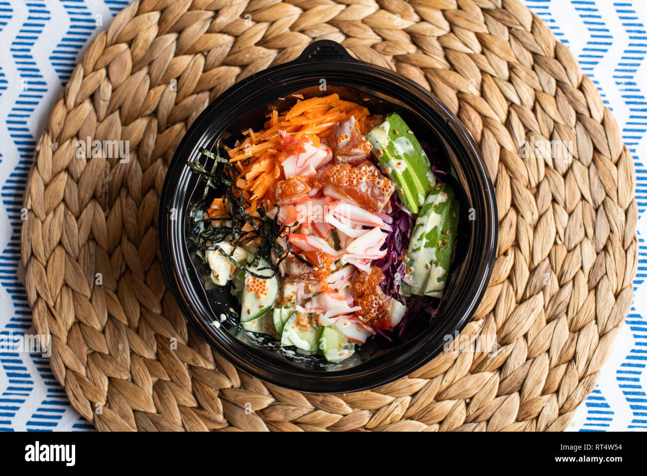 hawaii poke bowl with salmon, rice, surimi, avocado, tobiko, carrot and