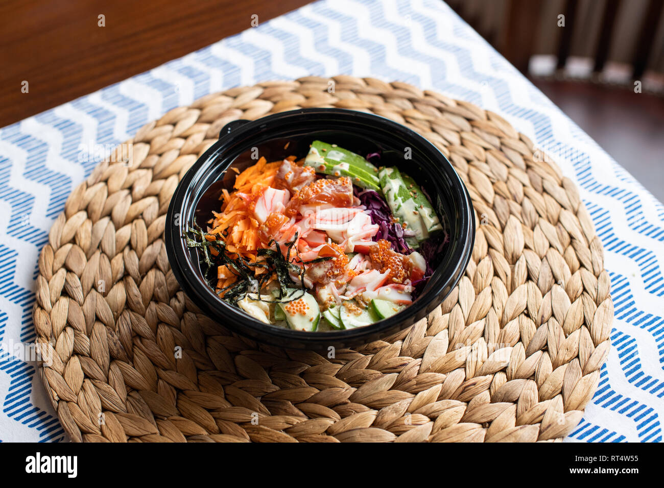 hawaii poke bowl with salmon, rice, surimi, avocado, tobiko, carrot and