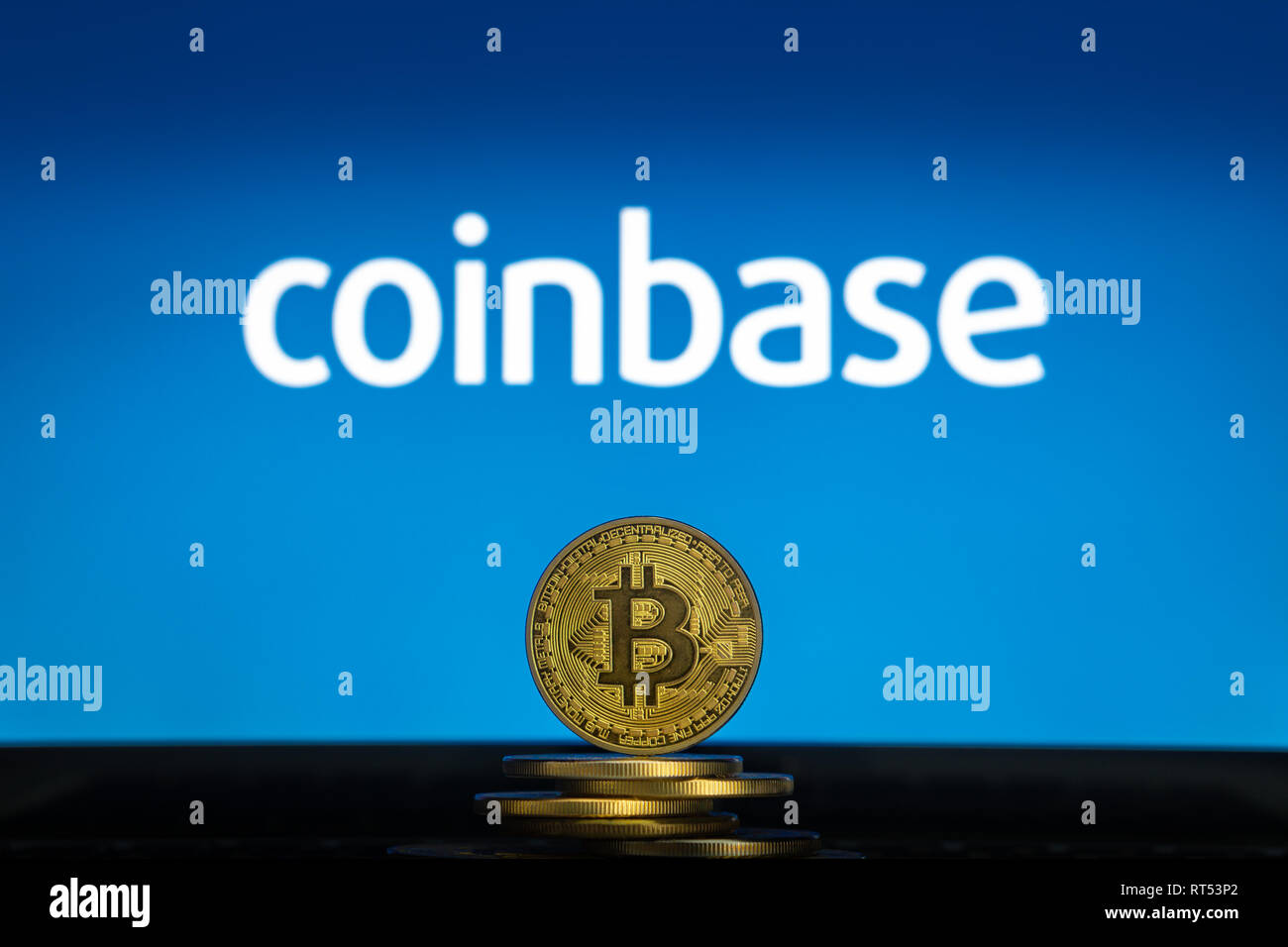 Bitcoin on a stack of coins with Coinbase logo on a laptop screen. Cryptocurrency and blockchain adoption getting mainstream. Slovenia - 02 24 2019 Stock Photo