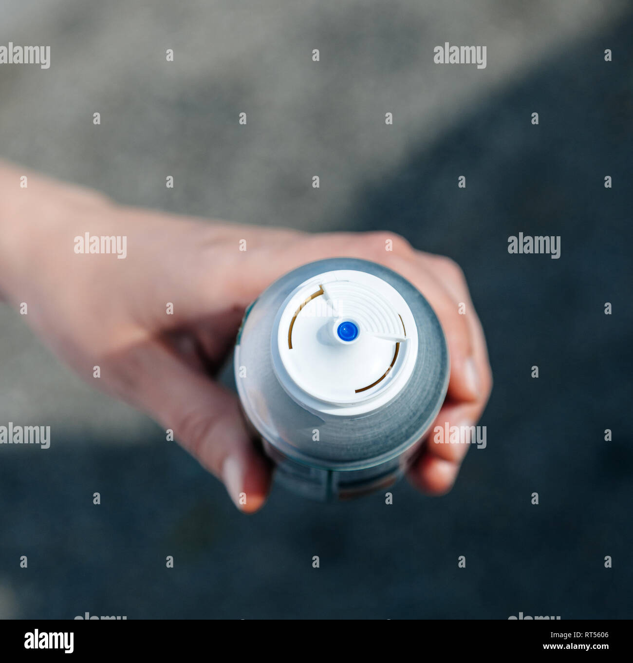 Woman holding aerosol bottle with canned compressed air in hand view