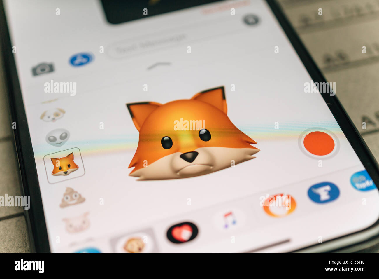 PARIS, FRANCE - NOV 9 2017: Fox animal 3d animoji emoji generated by Face ID facial recognition system with sad face emotion close-up of the new iphone X 10 Display - tilt-shift lens used  Stock Photo