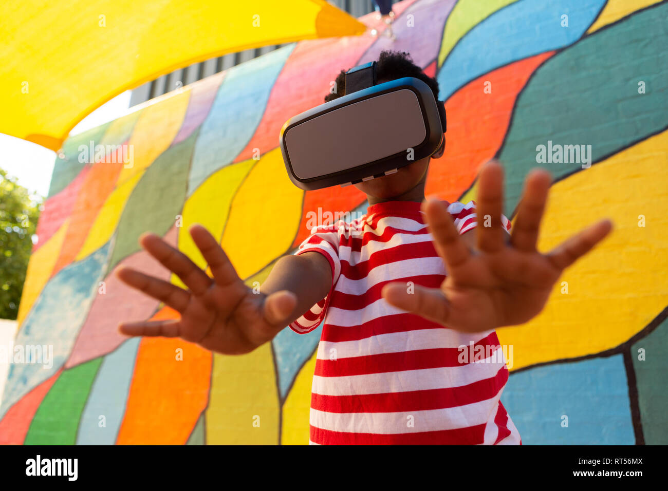 Schoolboy using virtual reality headset in the school playground Stock Photo