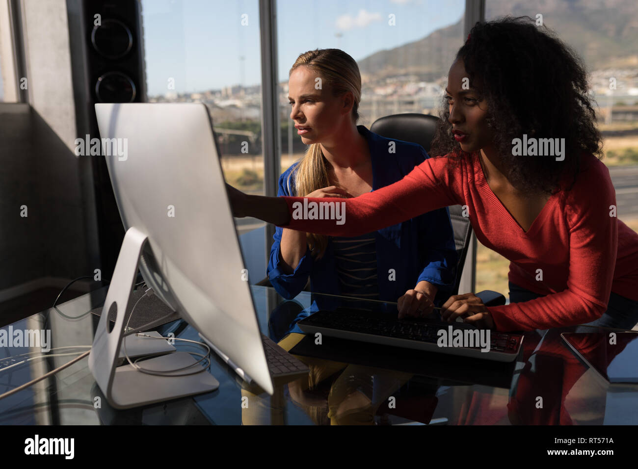 Female executives working on desktop pc at desk in office Stock Photo ...