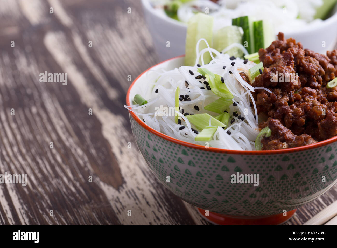 Asian style bowl with ground beef, rice noodles, cucumber, green onions