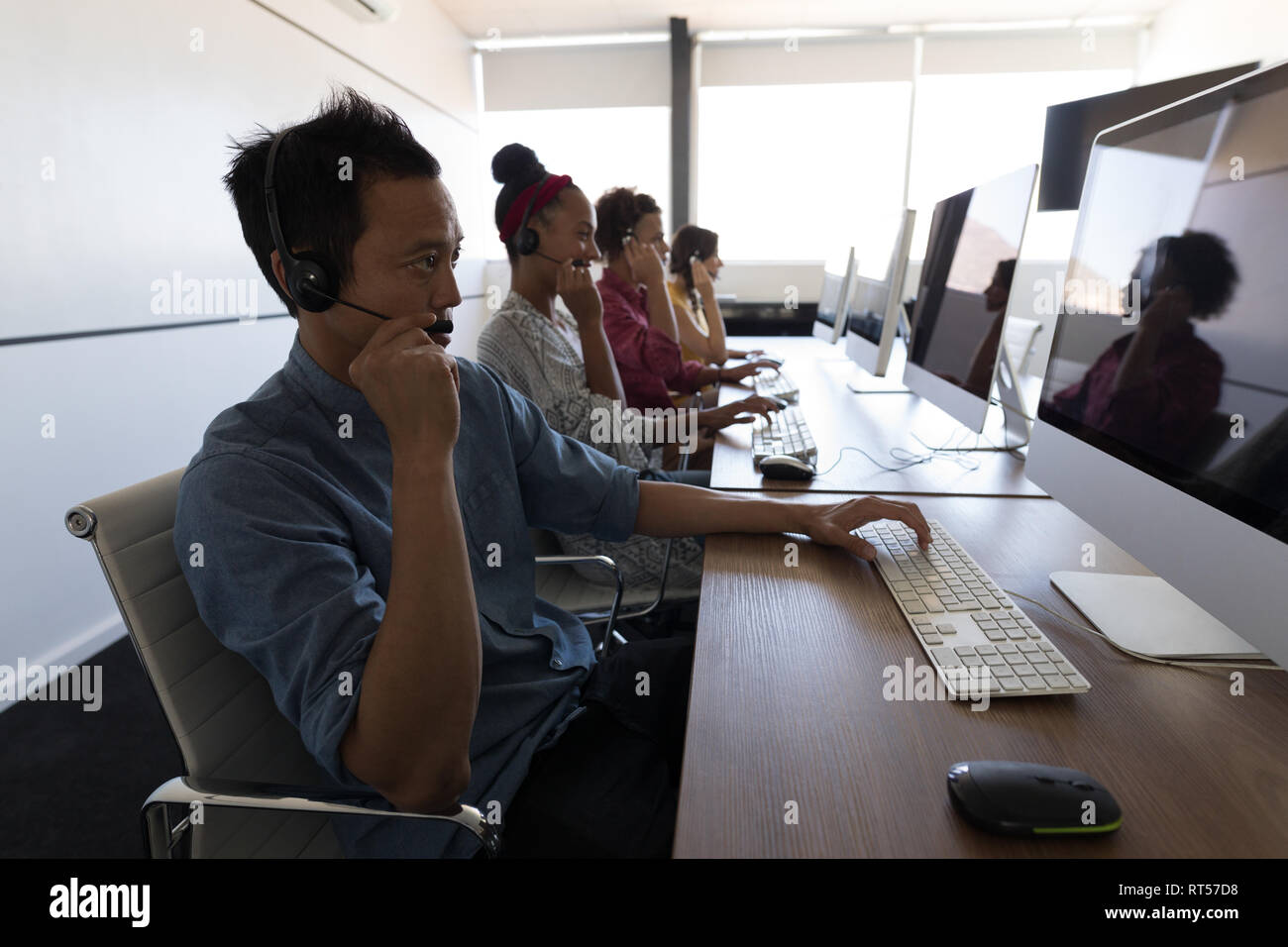 Executives talking on headset in office Stock Photo