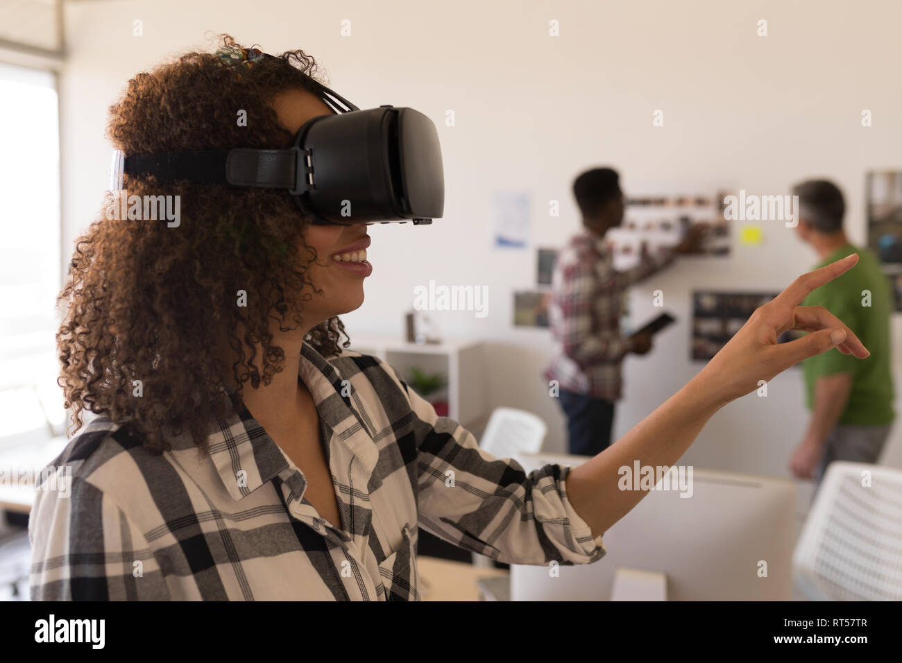 Female executive using virtual reality headset in office Stock Photo