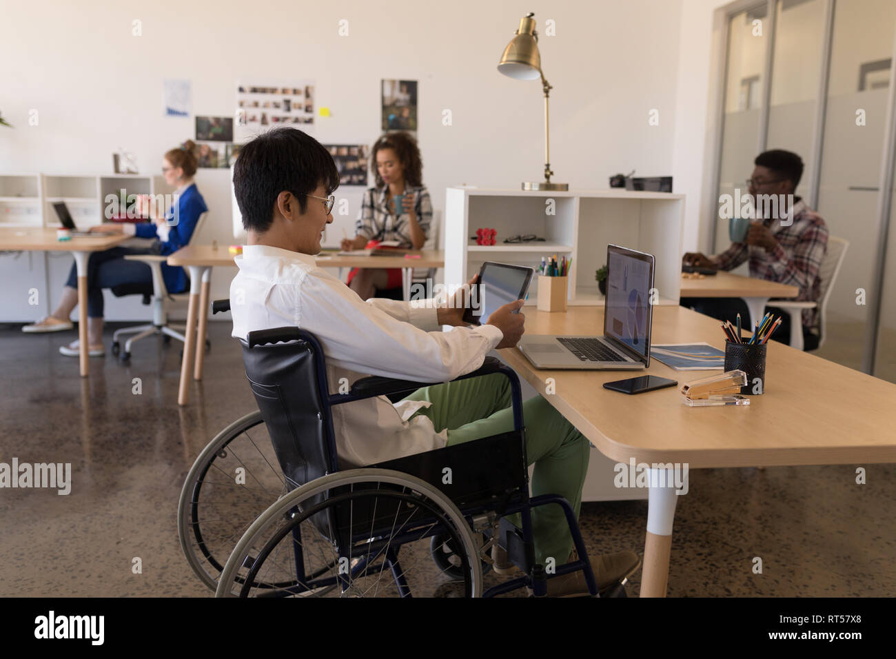 Disabled male executive using digital tablet at desk Stock Photo