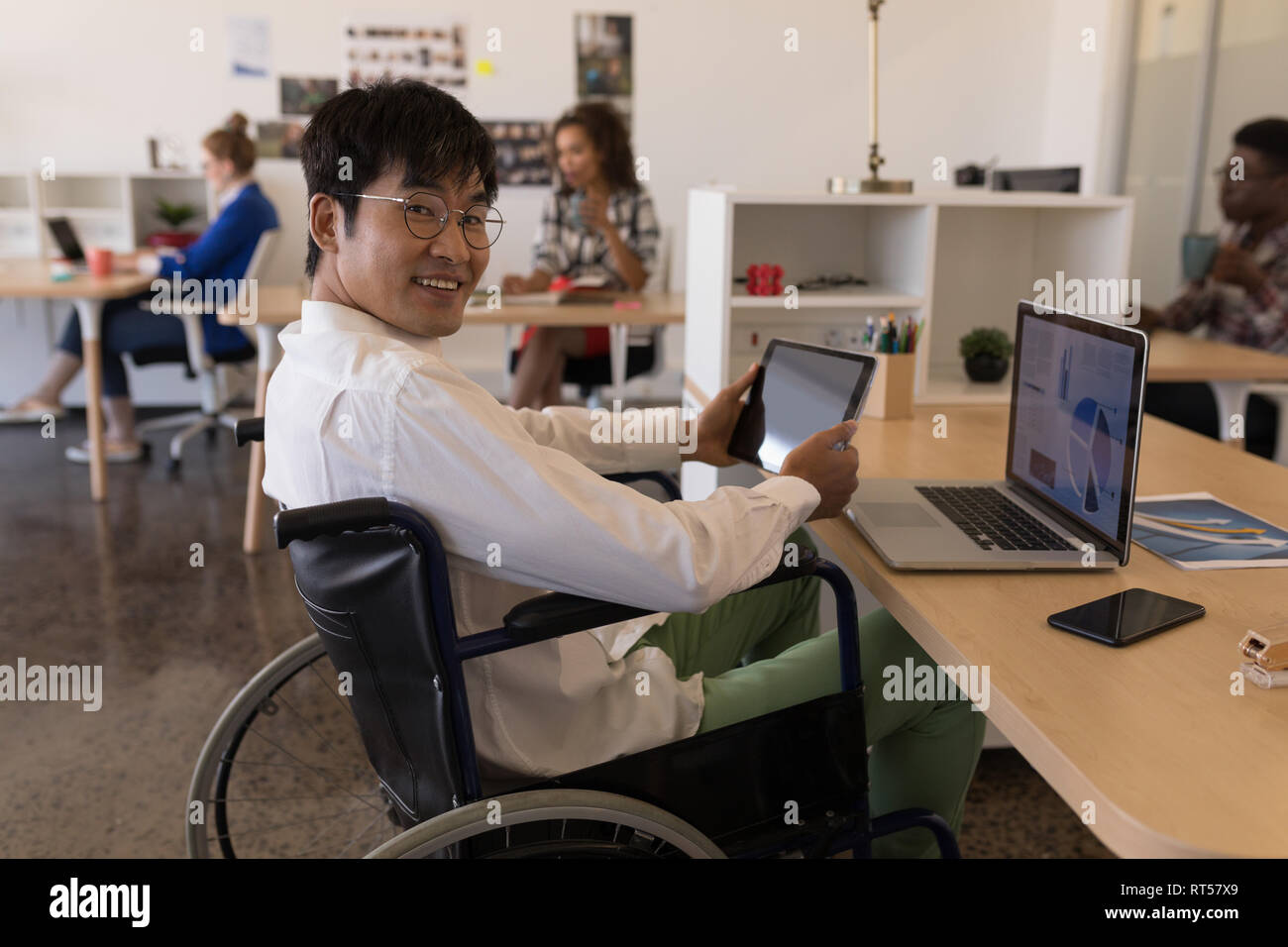 Disabled male executive using digital tablet at desk Stock Photo