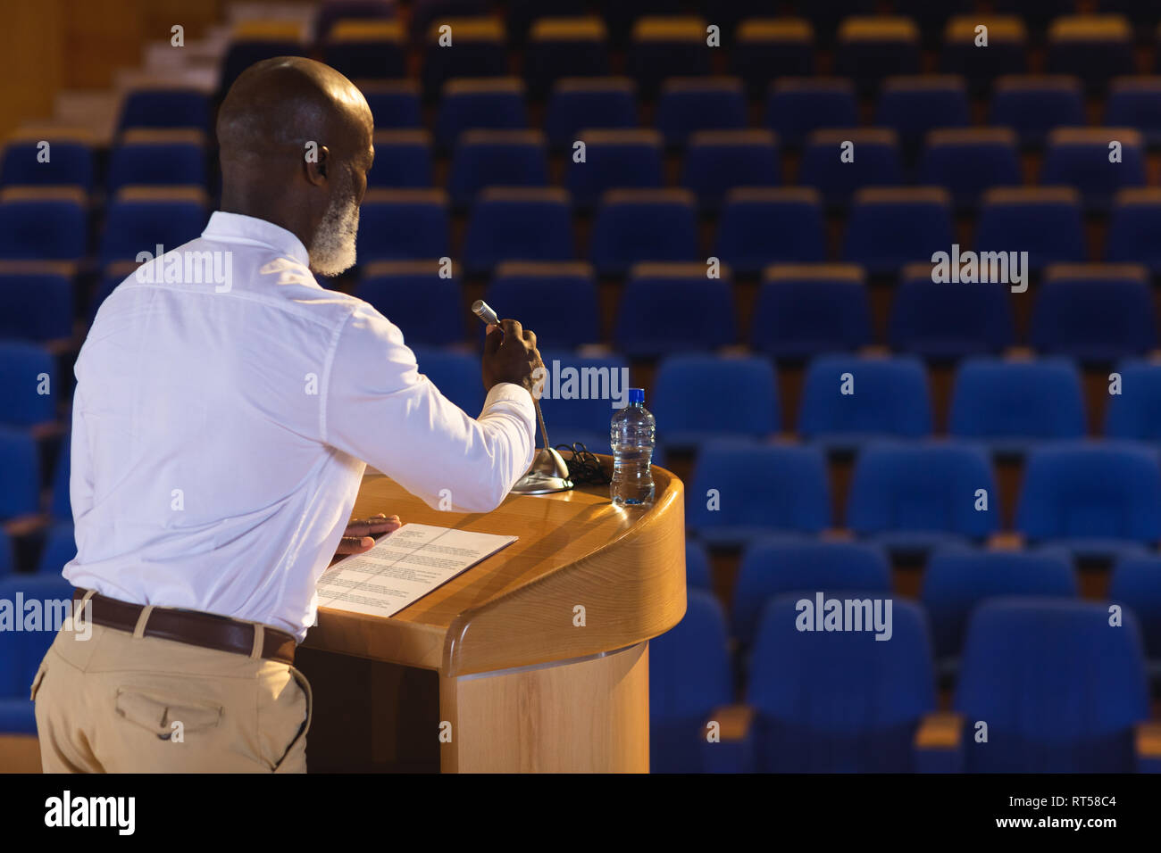 Matured businessman practicing for speech in the empty auditorium Stock Photo