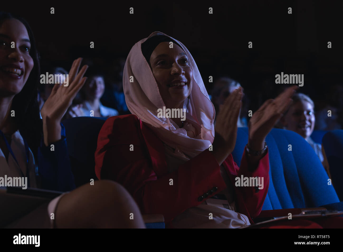 Businesswoman sitting  and clapping in the auditorium Stock Photo