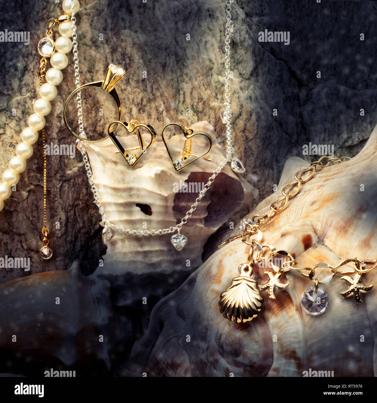 Treasure, gold jewelry, necklace rings and earrings on a seashell