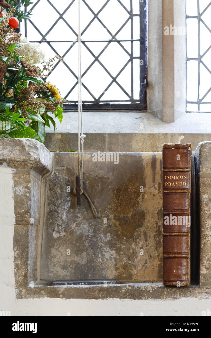 Old prayer book and leaded windows in an ancient English church Stock