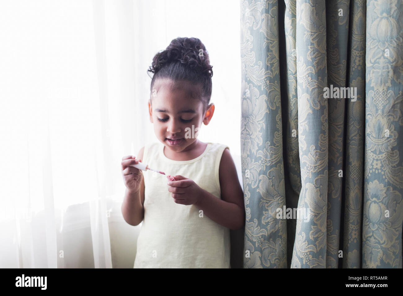 Toddler girl with lip gloss Stock Photo