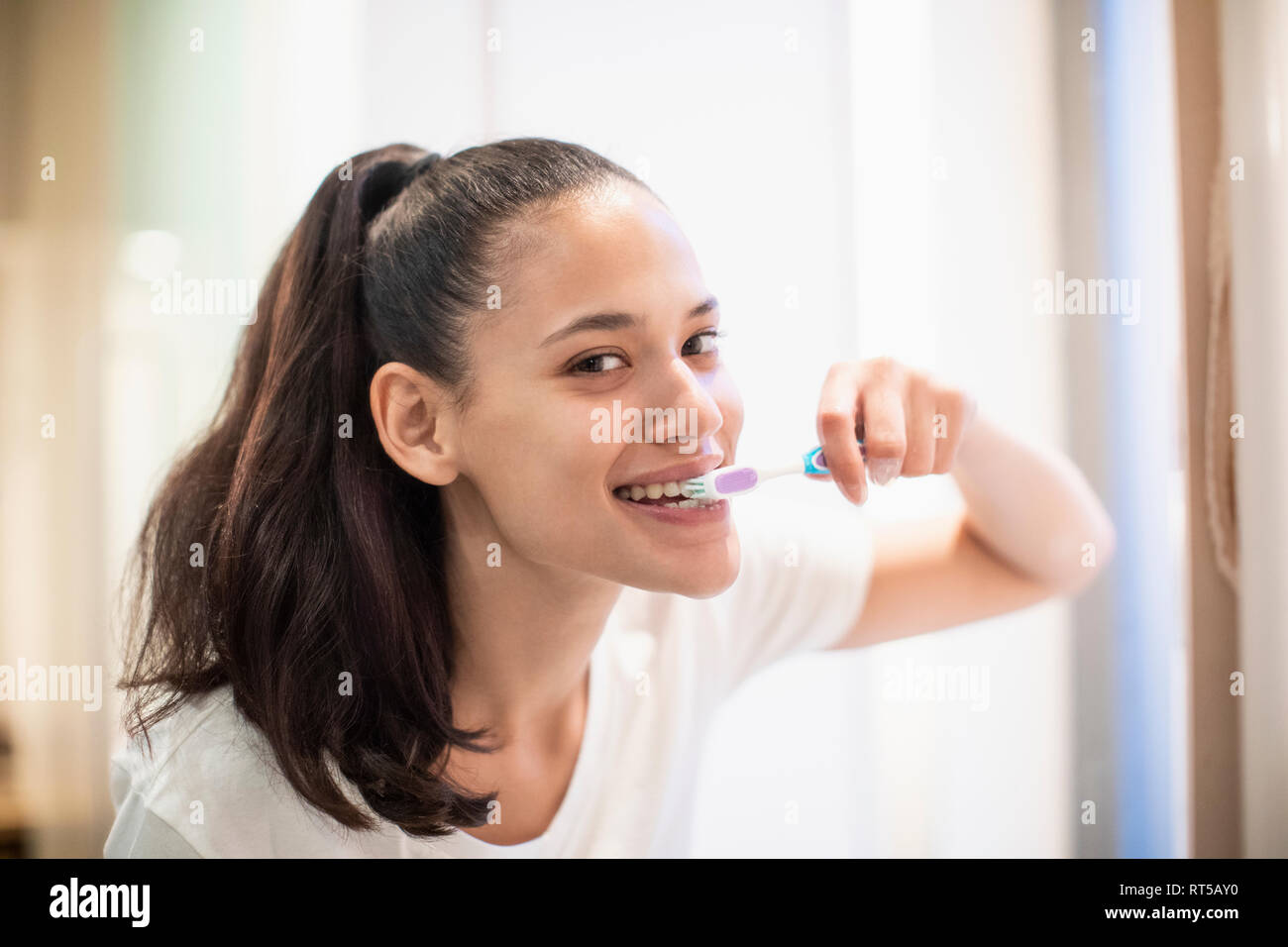 Portrait confident woman brushing teeth Stock Photo