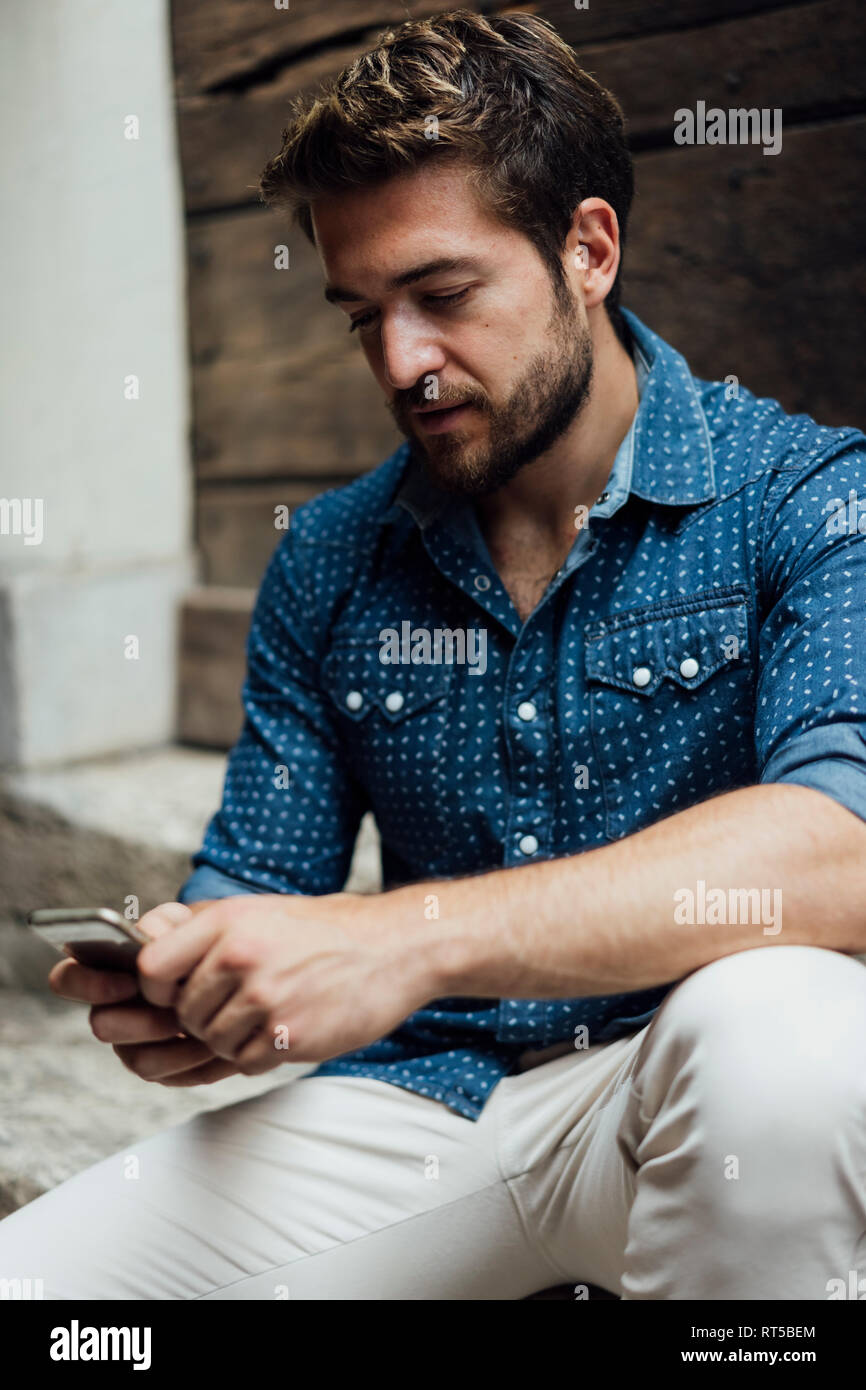 Businessman text messaging outdoors Stock Photo