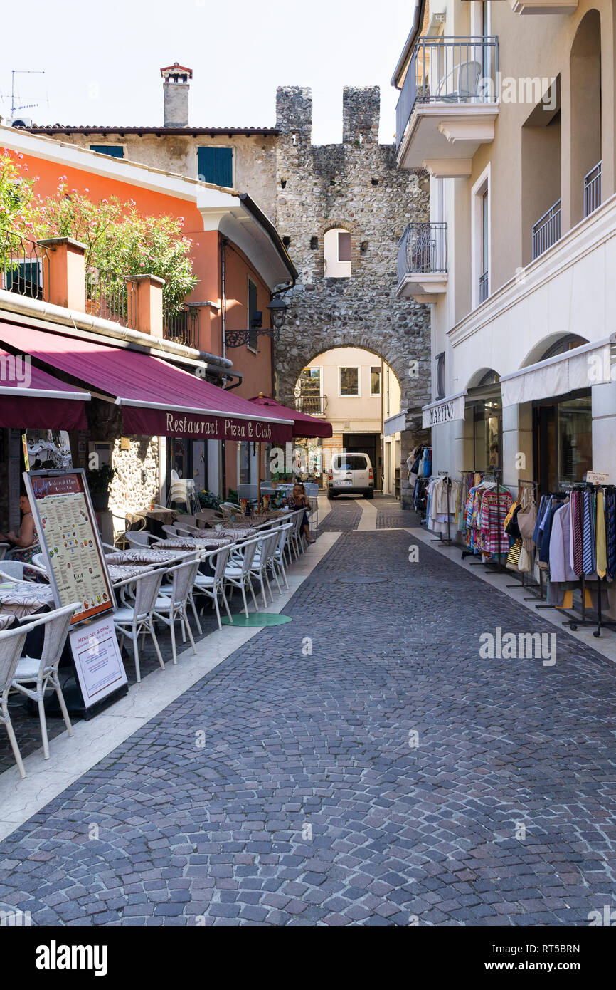 BARDOLINO, VENETO REGION, ITALY - AUGUST 7, 2017: Restaurant and shops on the street in Bardolino near the San Giovanni Gate. Stock Photo