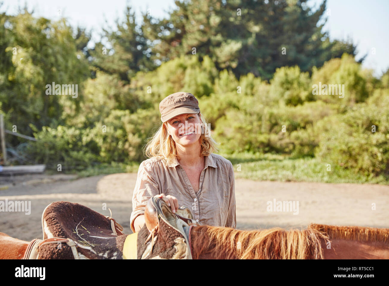 Portrait of smiling woman with a horse Stock Photo