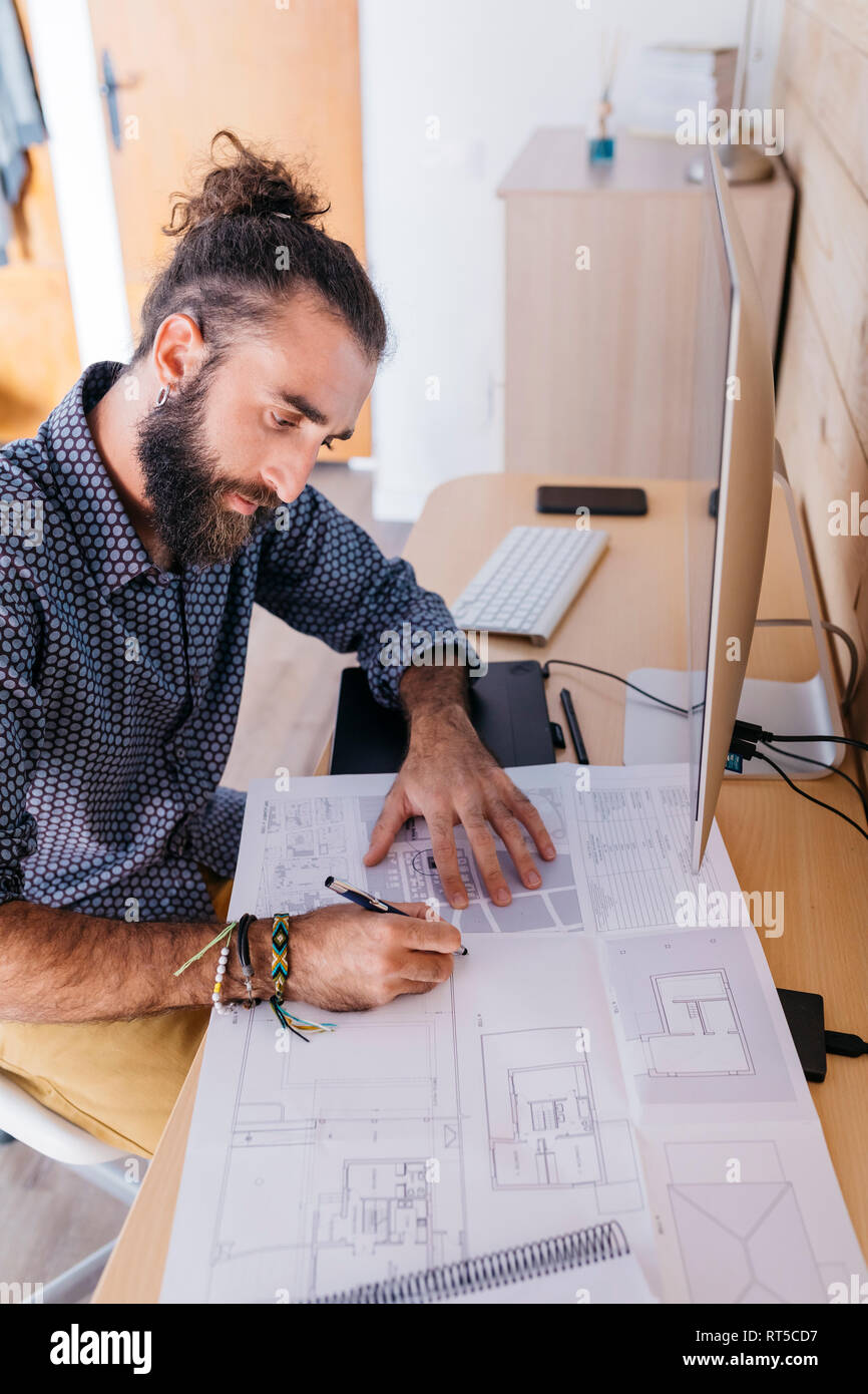 Young architect working at home with blueprints Stock Photo