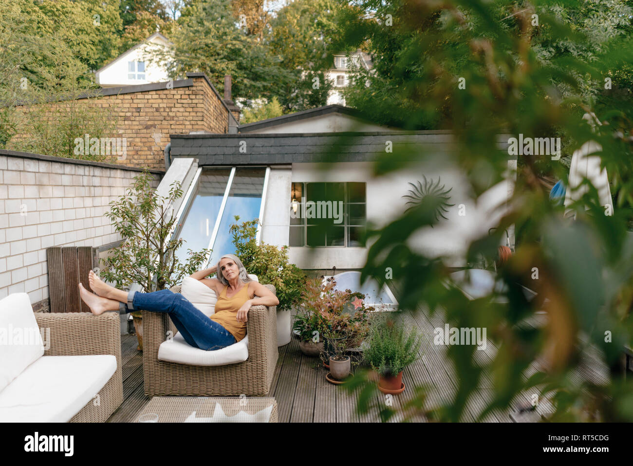 Woman relaxing on terrace Stock Photo - Alamy