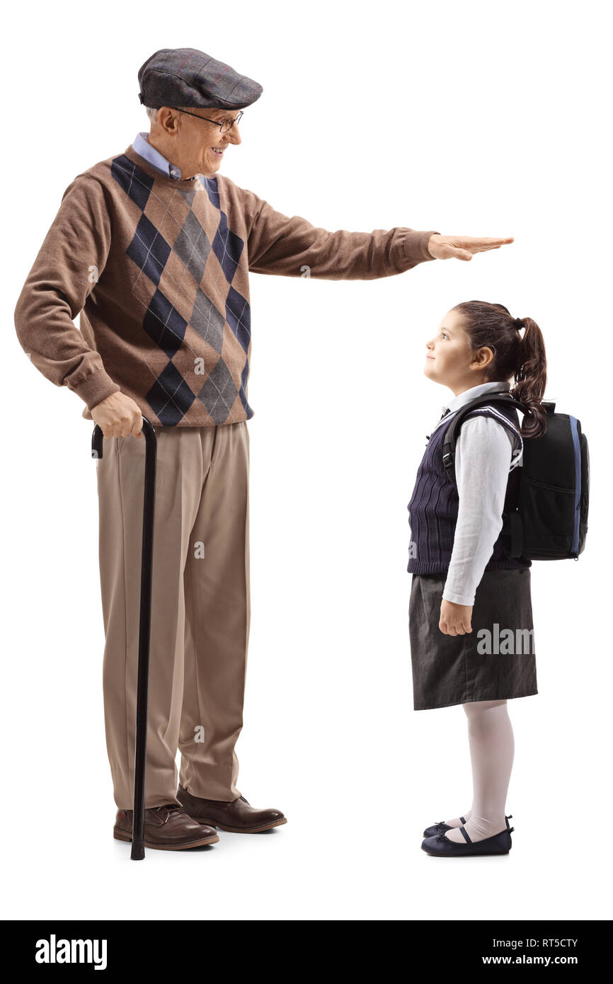Full length shot of a grandfather gesturing with hand and showing the height of his granddaughter isolated on white background Stock Photo