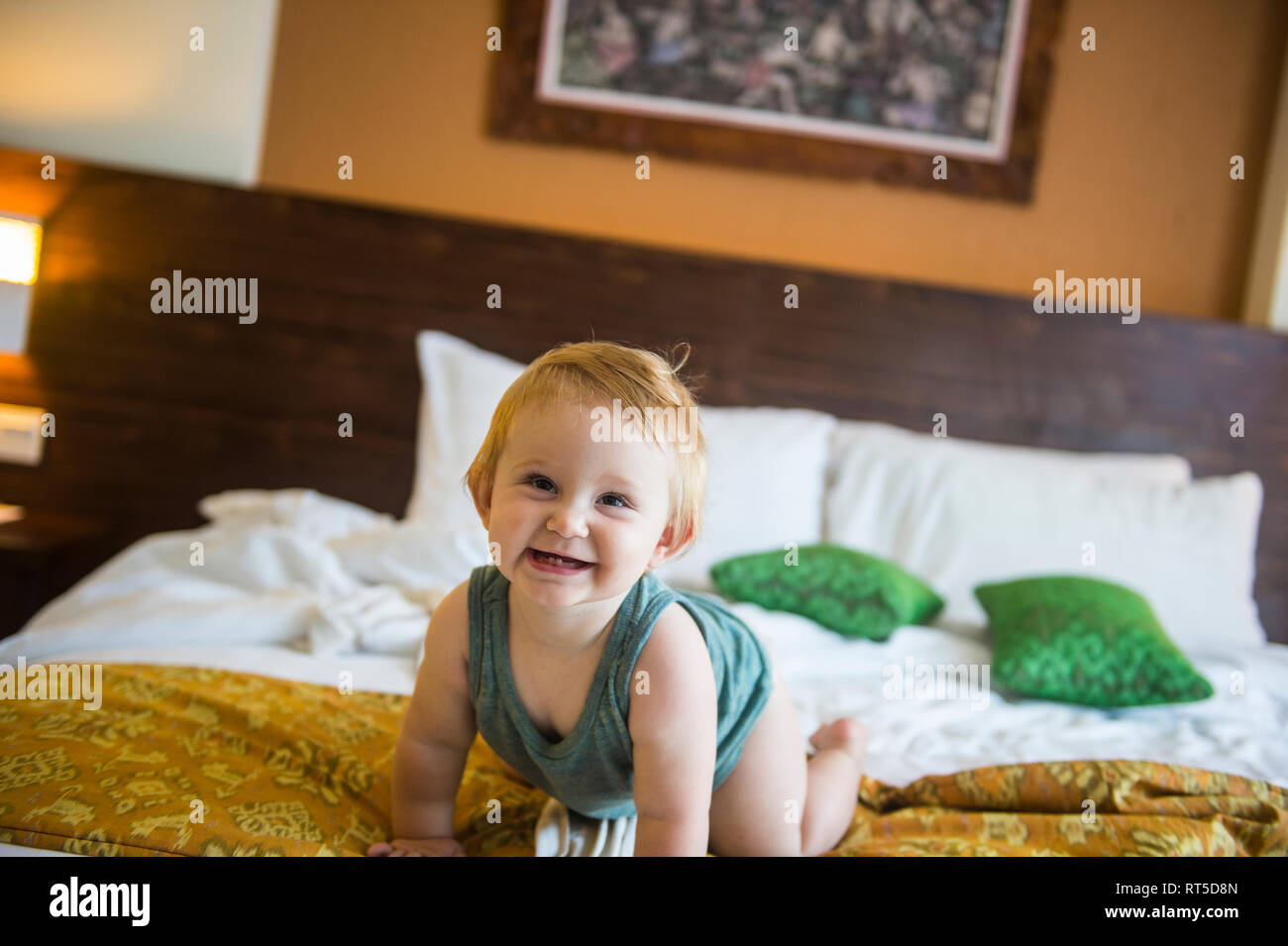 Baby girl on bed in hotel room Stock Photo Alamy