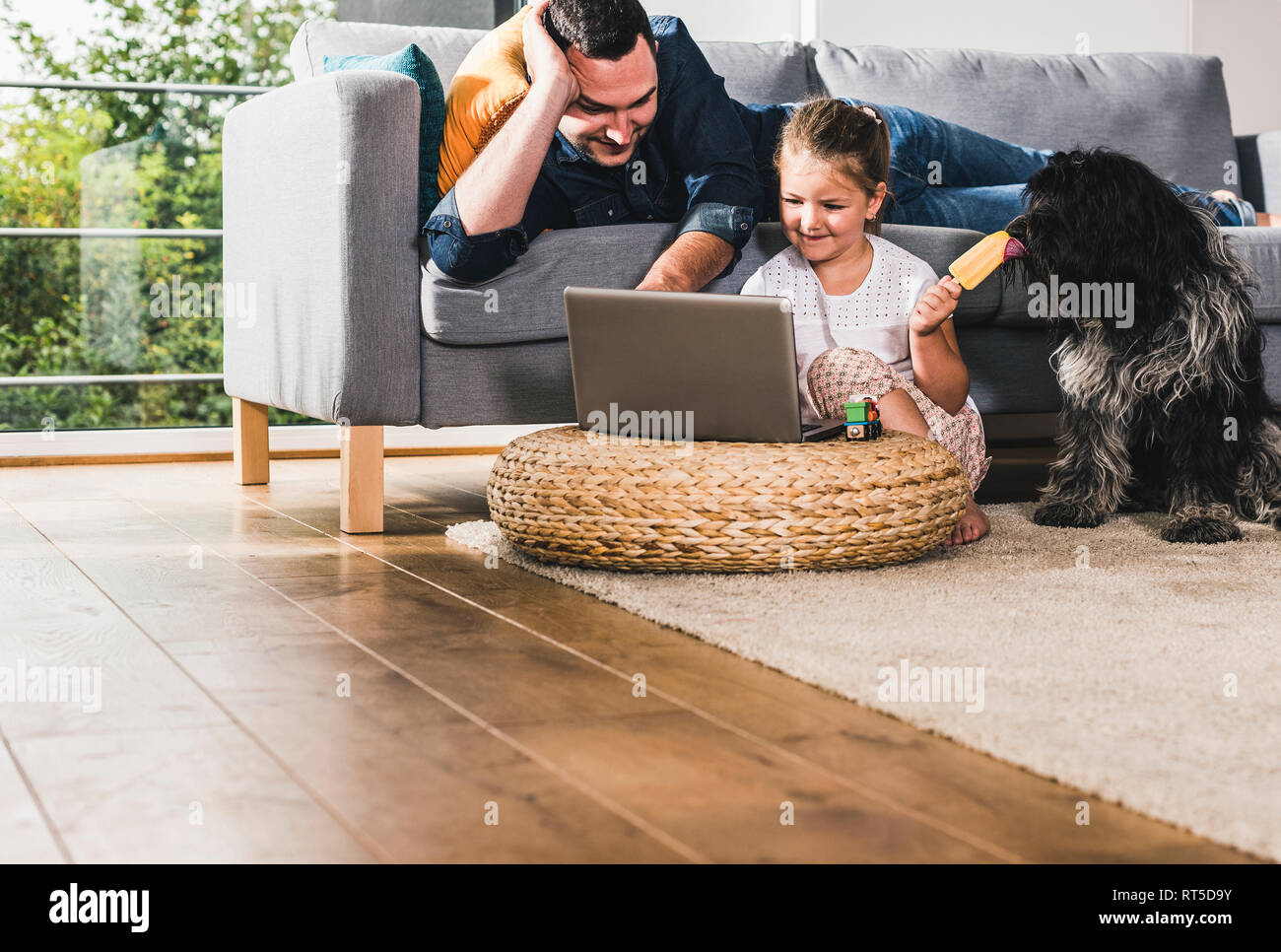 Father using laptop at home with his little daughter Stock Photo - Alamy