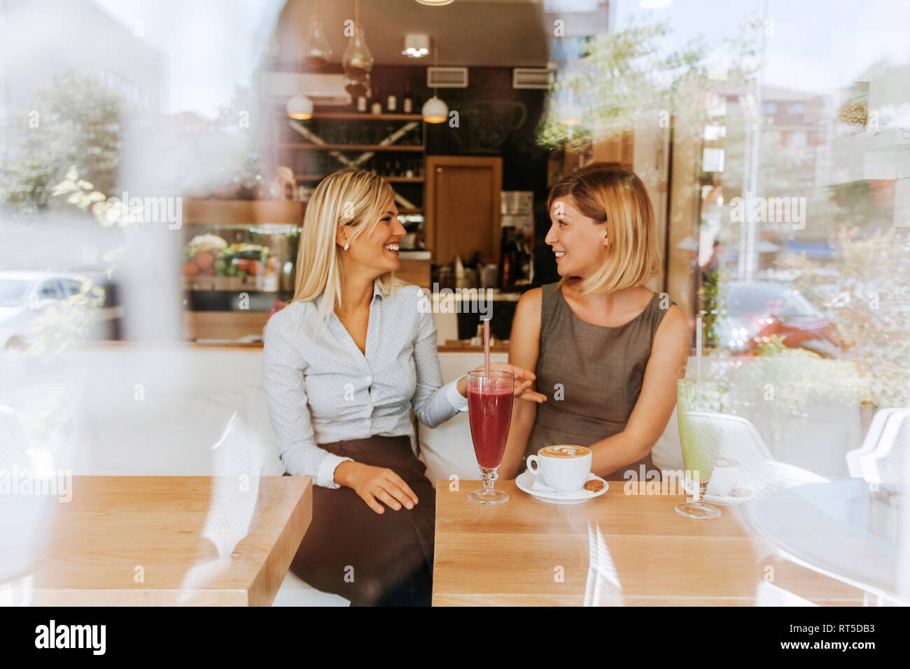 Two happy young women in a cafe Stock Photo