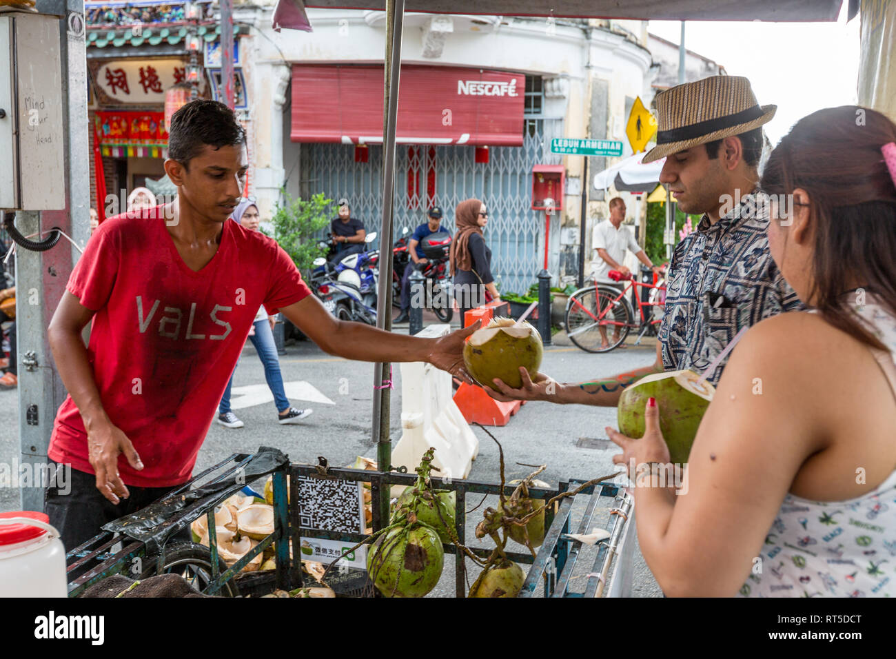 George Town, Penang, Malaysia.  Coconut Vendor Selling to a Customer. Stock Photo