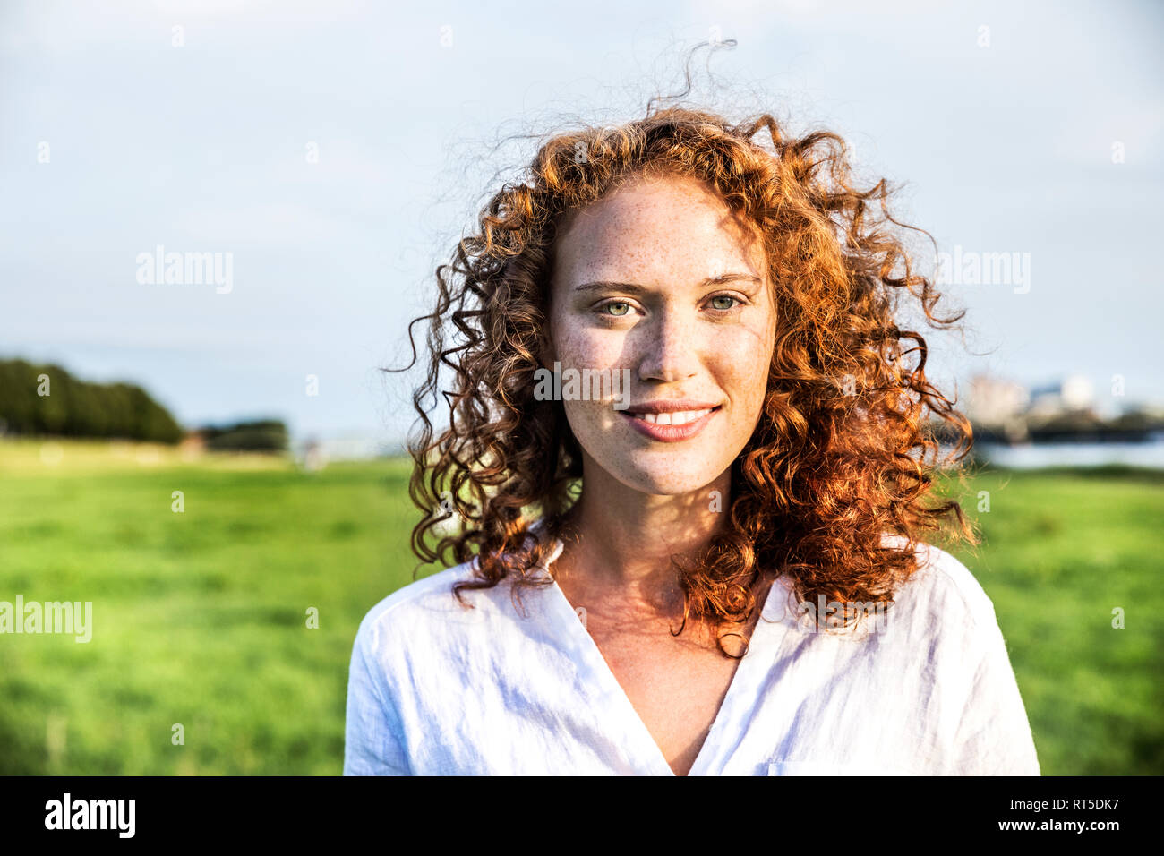Portrait of freckled young woman with curly red hair Stock Photo
