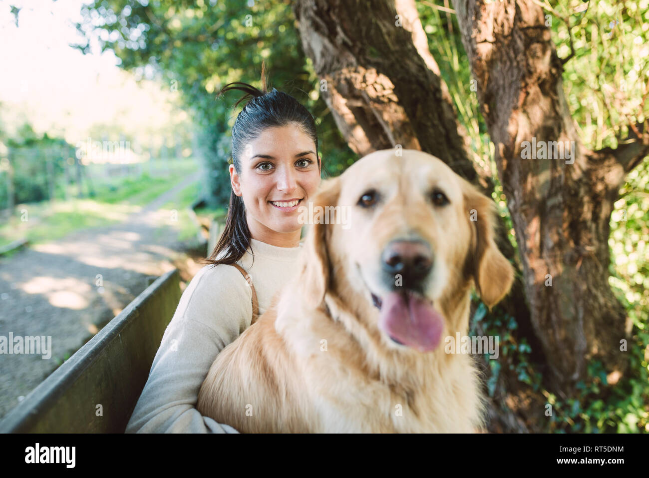 Portrait of a smiling young woman with her Golden retriever dog Stock Photo