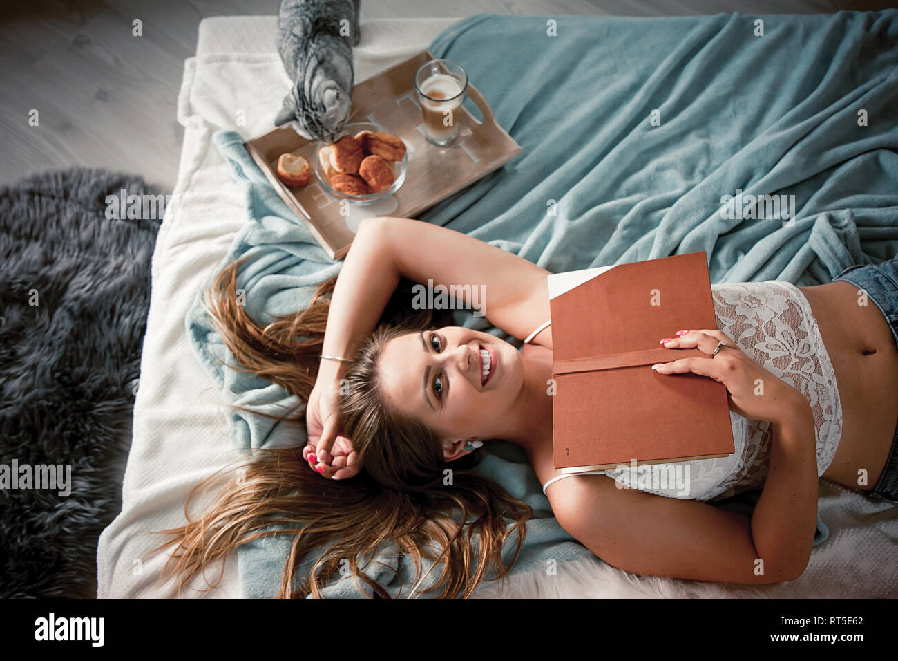 Young woman reading a book at home Stock Photo