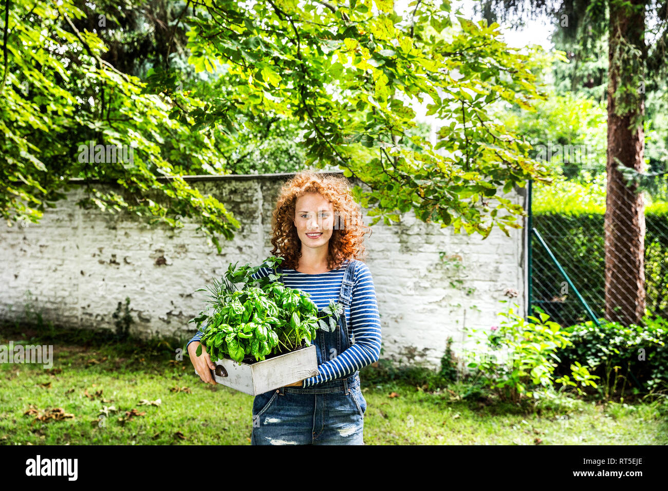 Portrait of young woman with fresh herbs in a box Stock Photo
