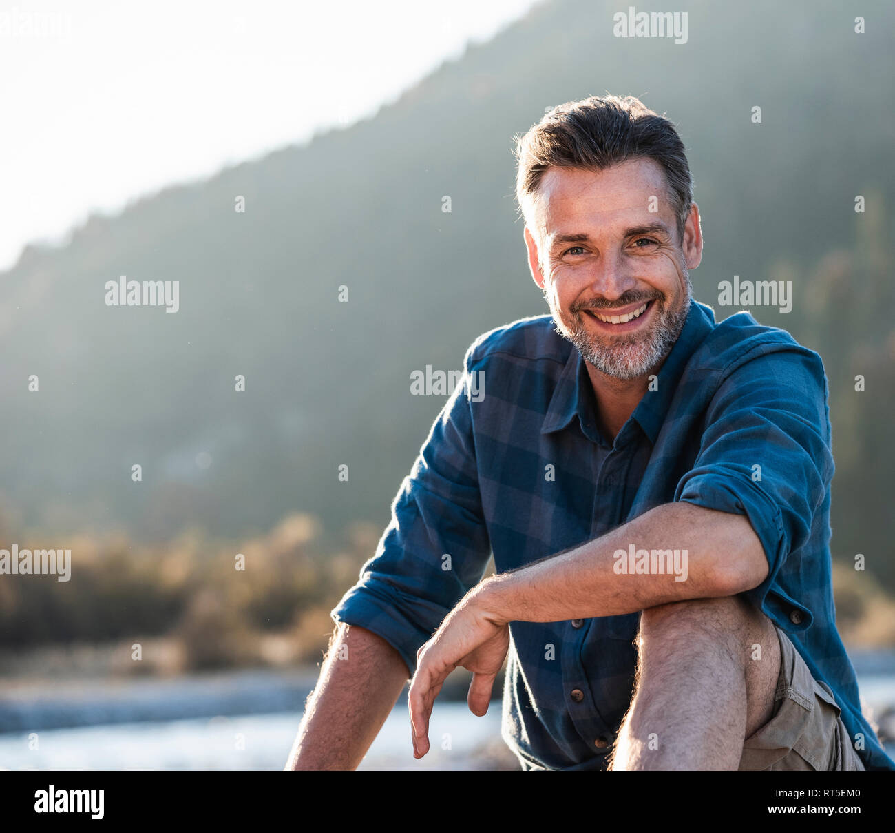 Mature man camping at riverside Stock Photo