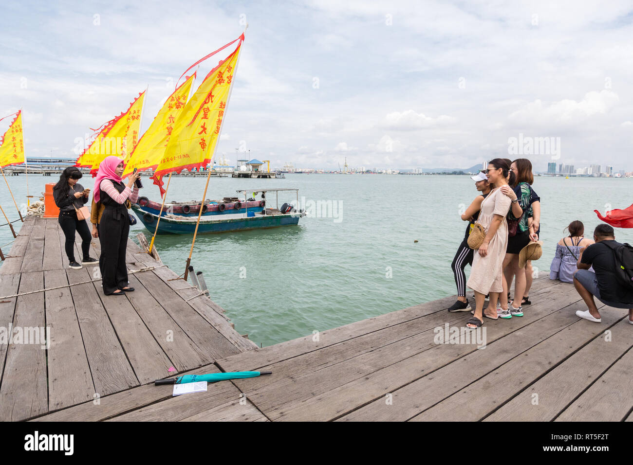 George Town, Penang, Malaysia.  Tourists Making Photos at end of Chew Jetty, a Historic Chinese Settlement. Stock Photo