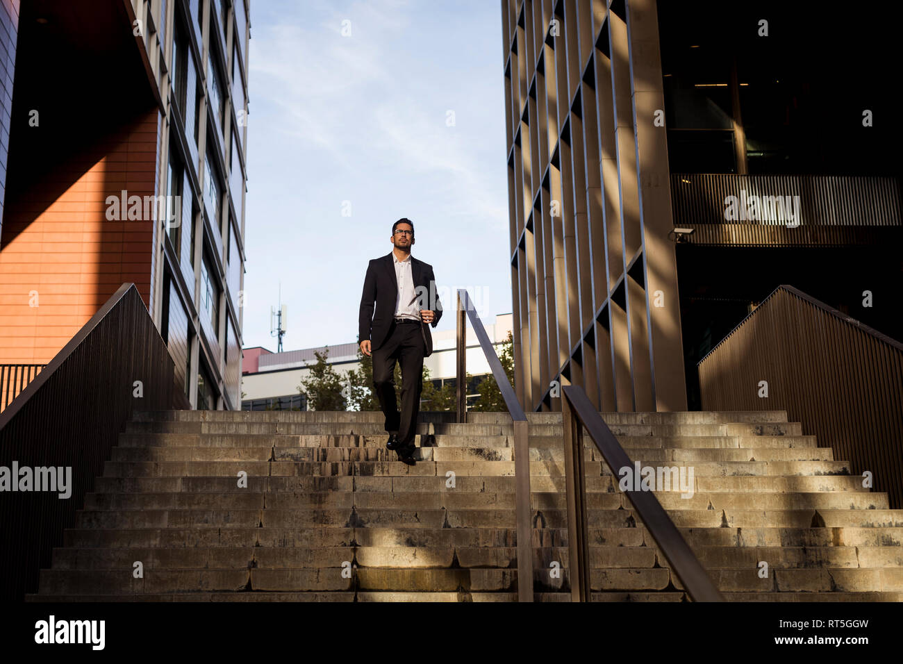 Businessman walking down stairs in the city Stock Photo