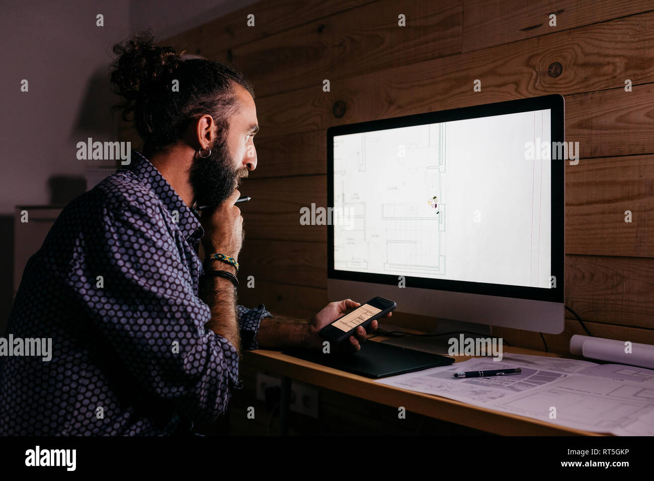 Young architect working hard on a new project at home at night Stock Photo