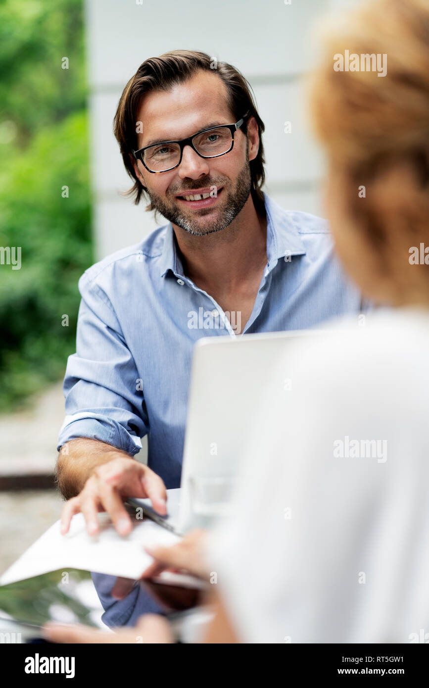Happy couple working from home, sitting in their garden Stock Photo