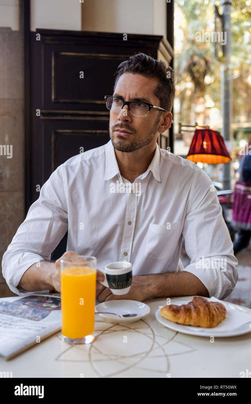 Businessman having breakfast in a cafe Stock Photo