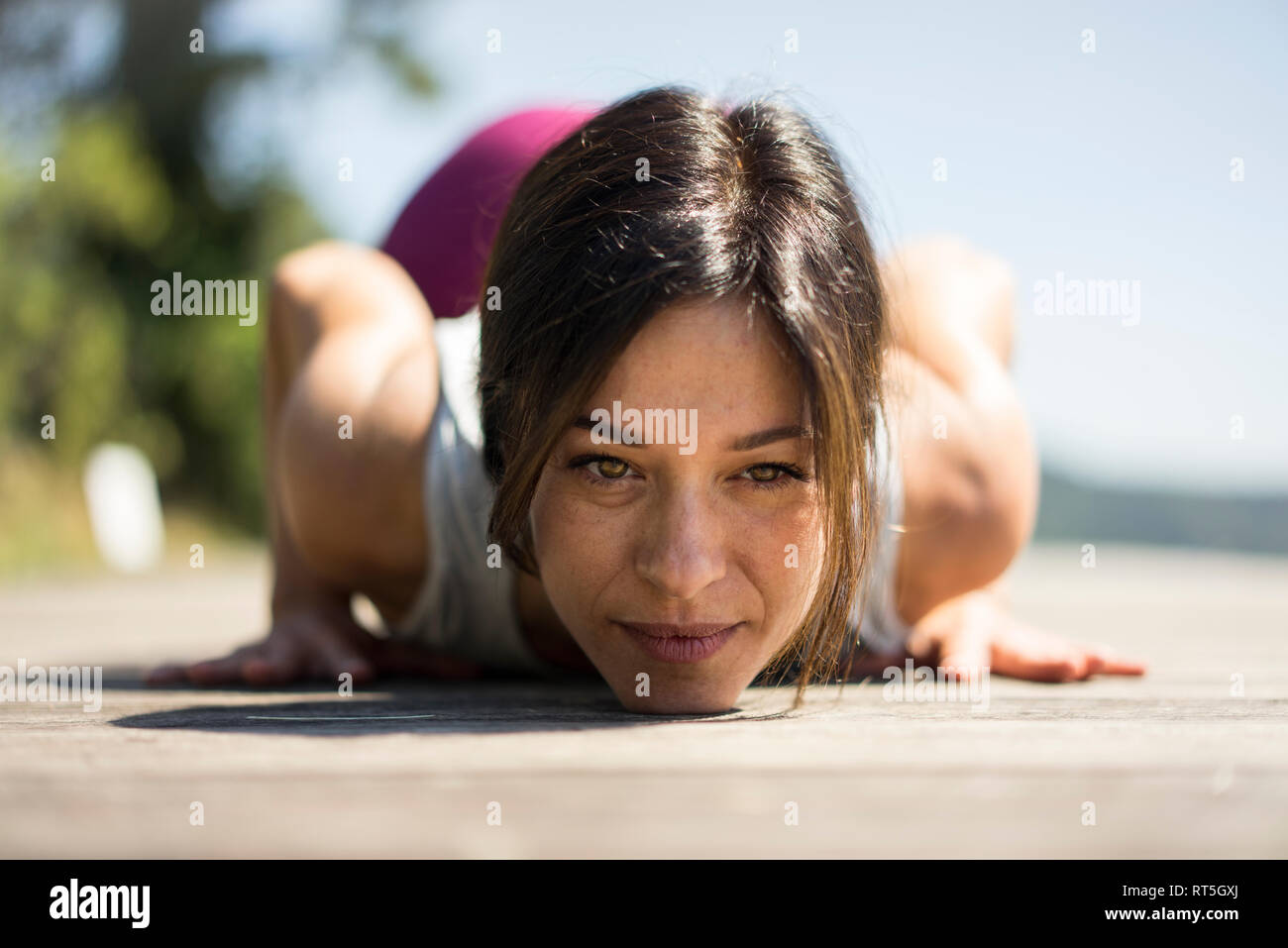 Mature woman practicing yoga in summer on a jetty Stock Photo