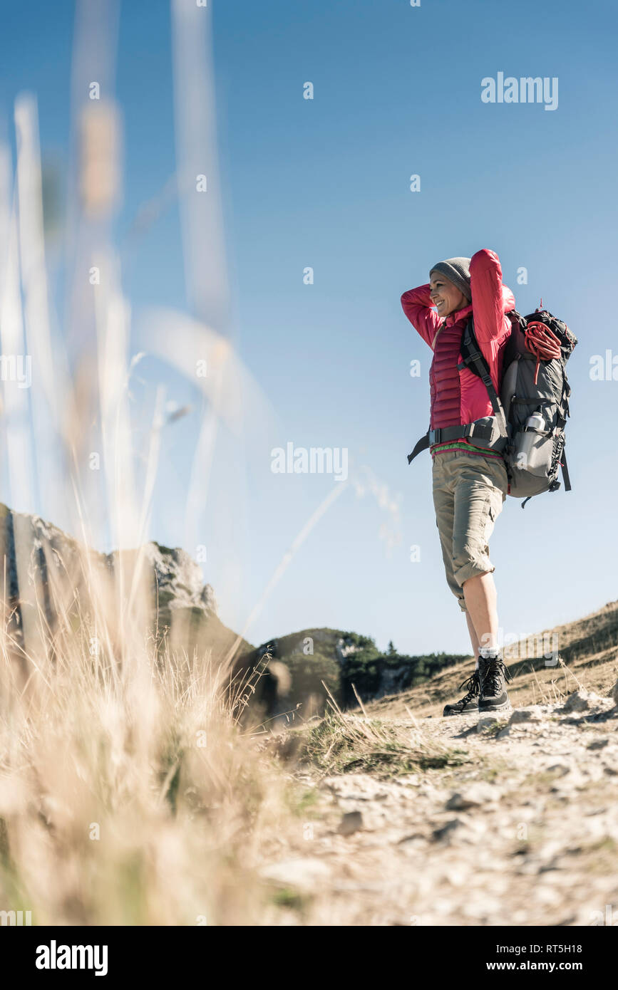 Austria, Tyrol, smiling woman on a hiking trip in the mountains enjoying the view Stock Photo