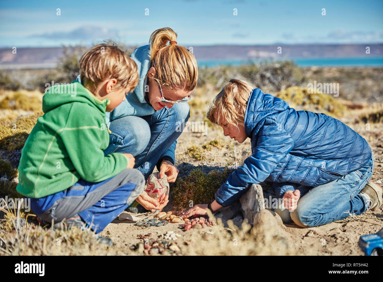 Argentina, Rio Chico, woman and sons collecting stones in the steppe Stock Photo
